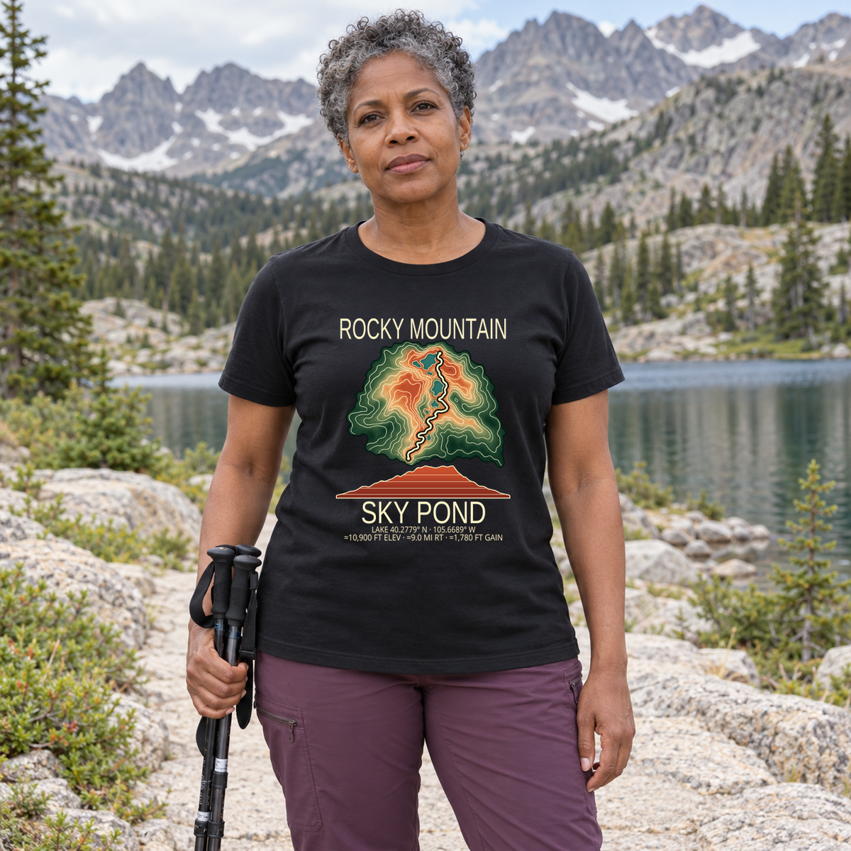 Illustrative lifestyle mockup of Sky Pond Hiking T-Shirt | Rocky Mountain on a black shirt in a generated outdoor scene.