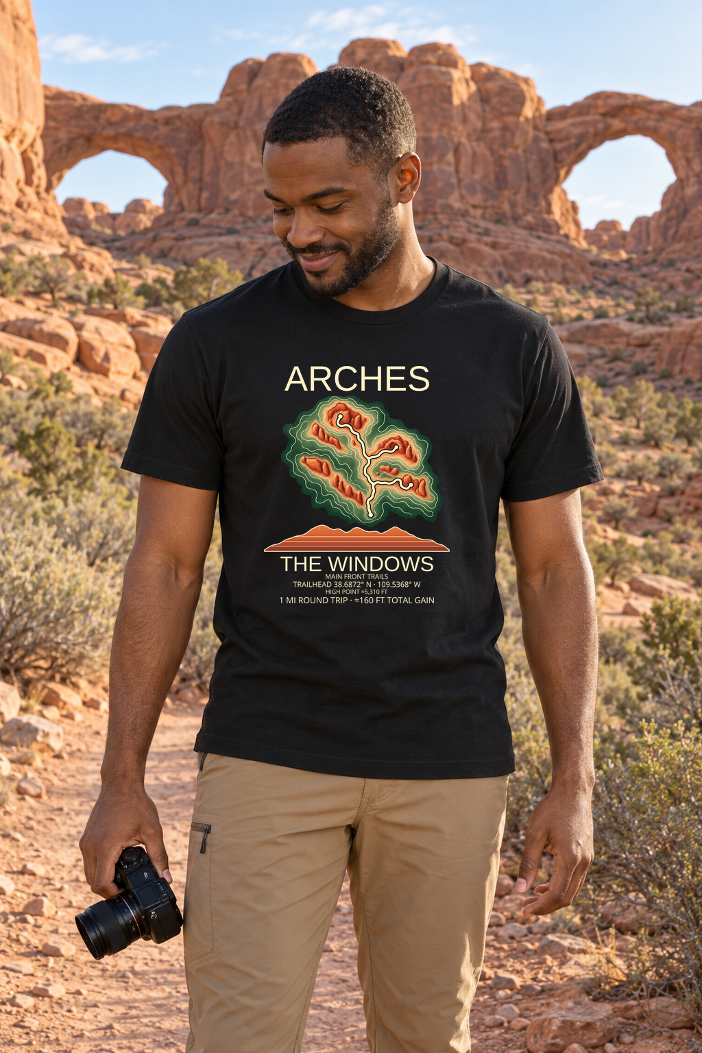 Illustrative lifestyle mockup of The Windows Hiking T-Shirt | Arches on a black shirt in a generated outdoor scene.