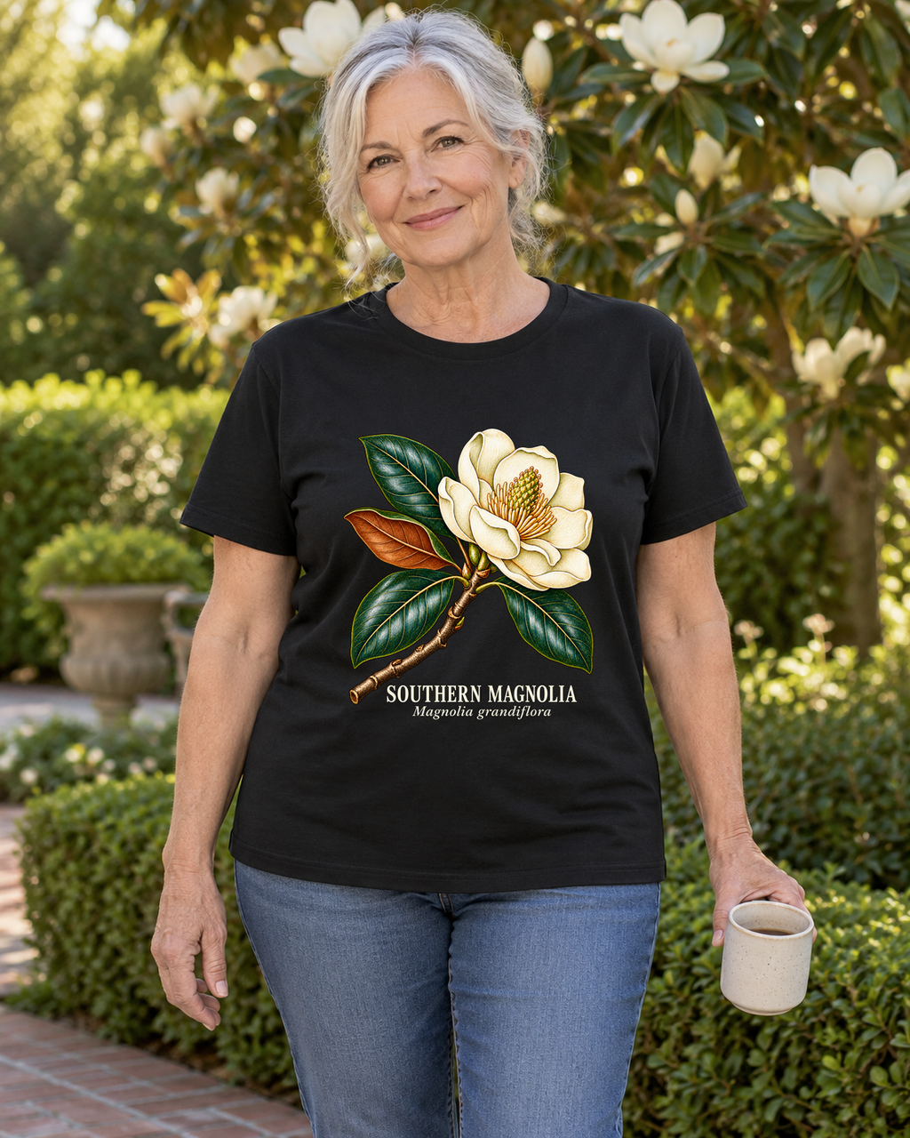 Illustrative lifestyle mockup of Southern Magnolia Botanical T-Shirt | Magnolia grandiflora on a black shirt in a generated outdoor scene.