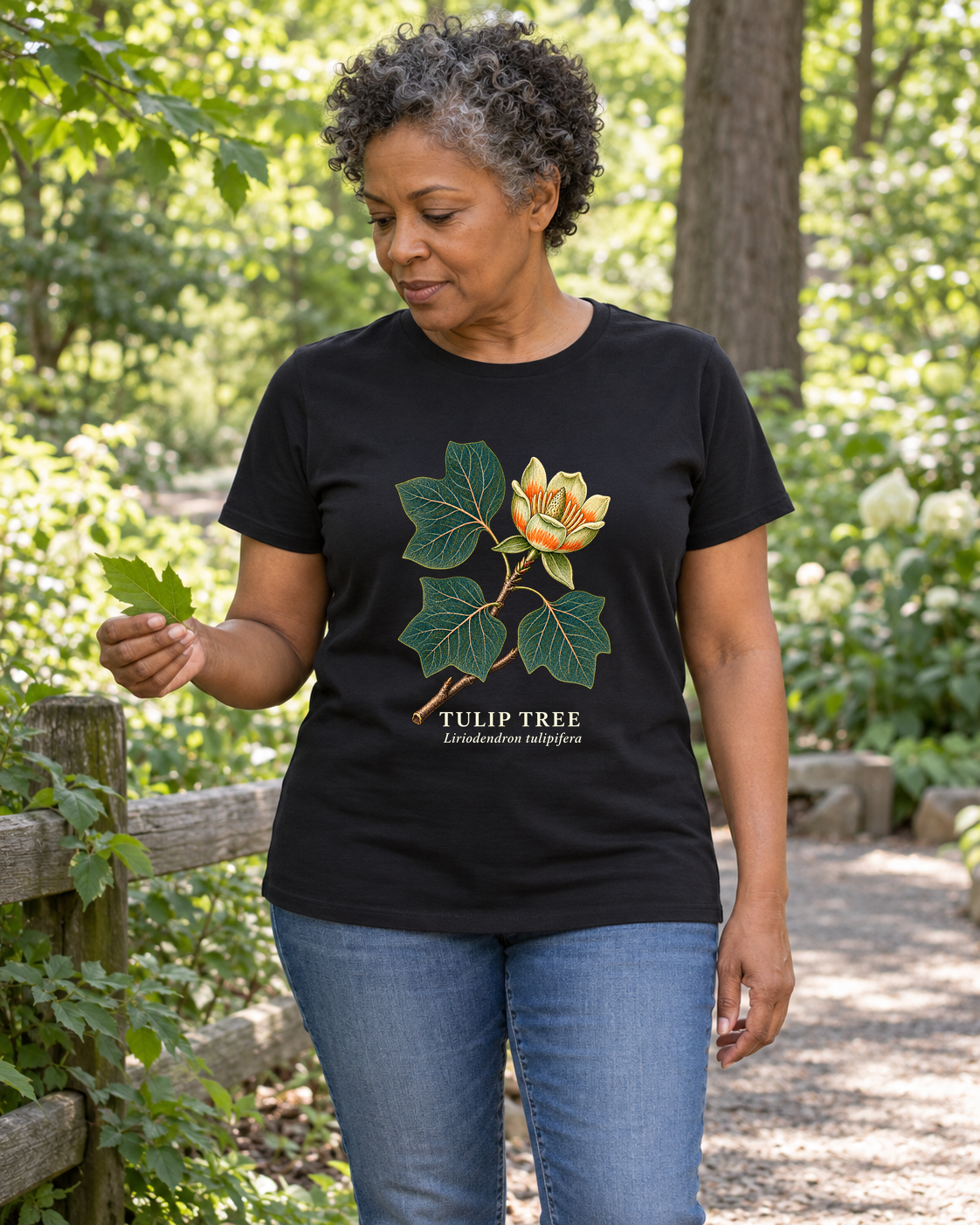 Illustrative lifestyle mockup of Tulip Tree Botanical T-Shirt | Liriodendron tulipifera on a black shirt in a generated outdoor scene.