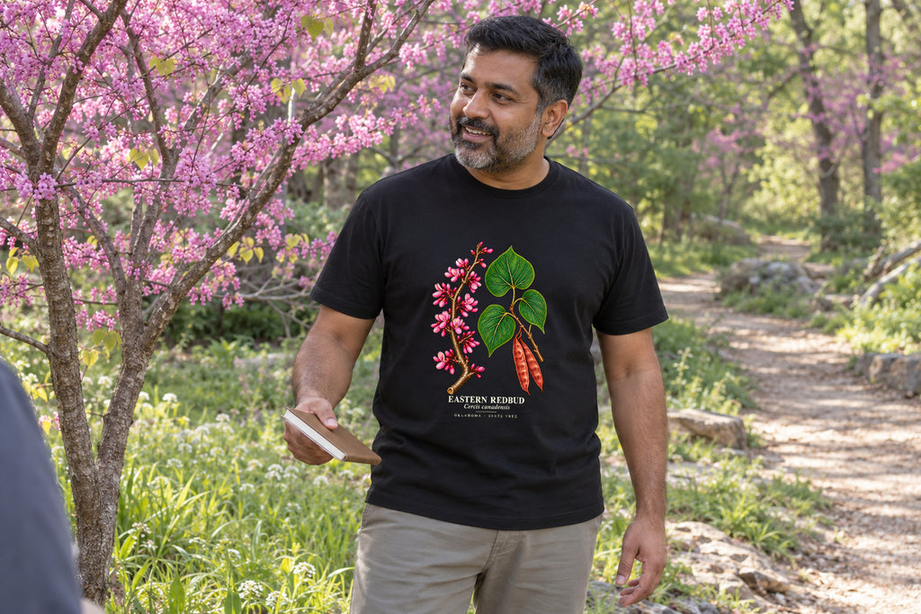 Illustrative lifestyle mockup of the Eastern Redbud Oklahoma State Tree T-Shirt on a black shirt in a generated scene.