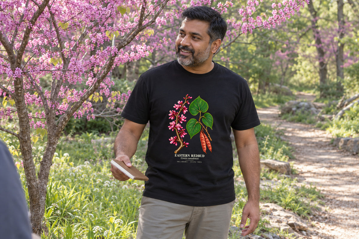 Illustrative lifestyle mockup of the Eastern Redbud Oklahoma State Tree T-Shirt on a black shirt in a generated scene.
